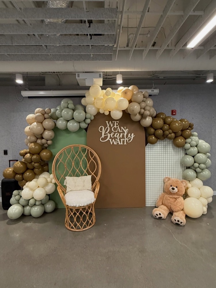 We Can Bearly Wait baby shower display with wicker chair and teddy bear