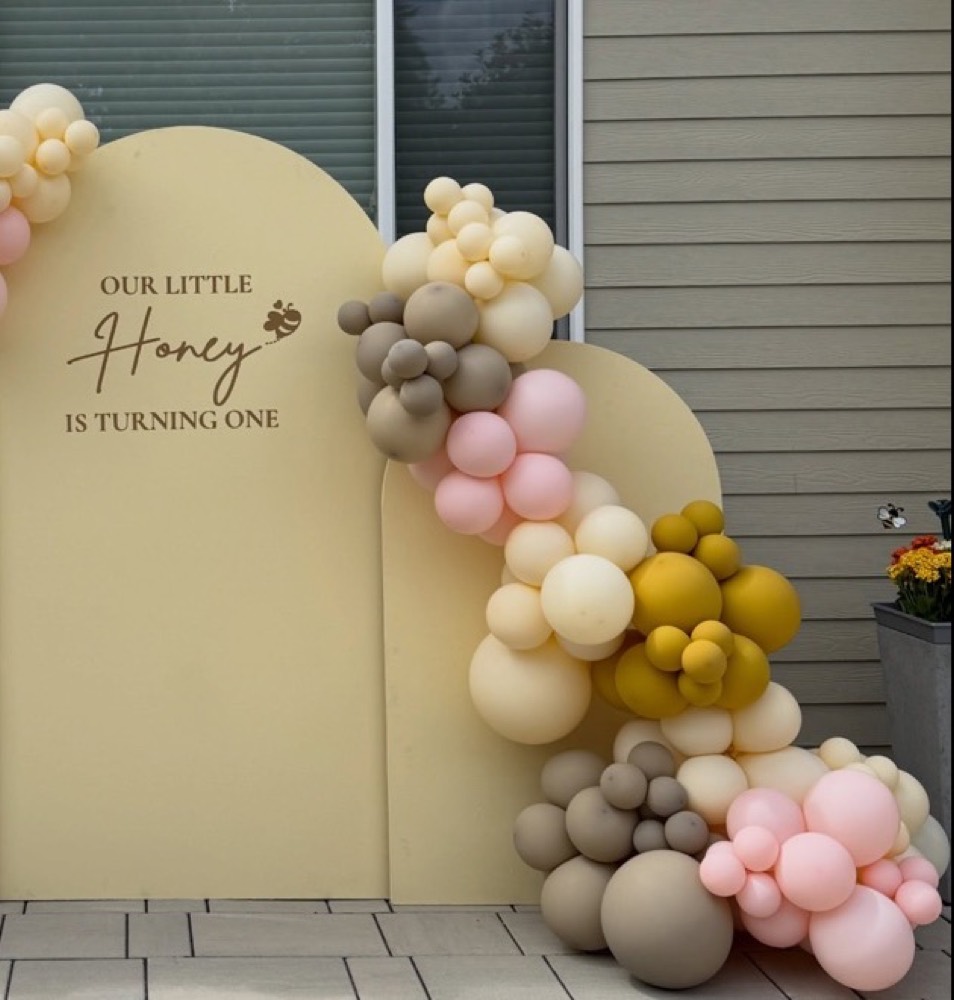Two panel display with half balloon arch, side bundle and custom vinyl text